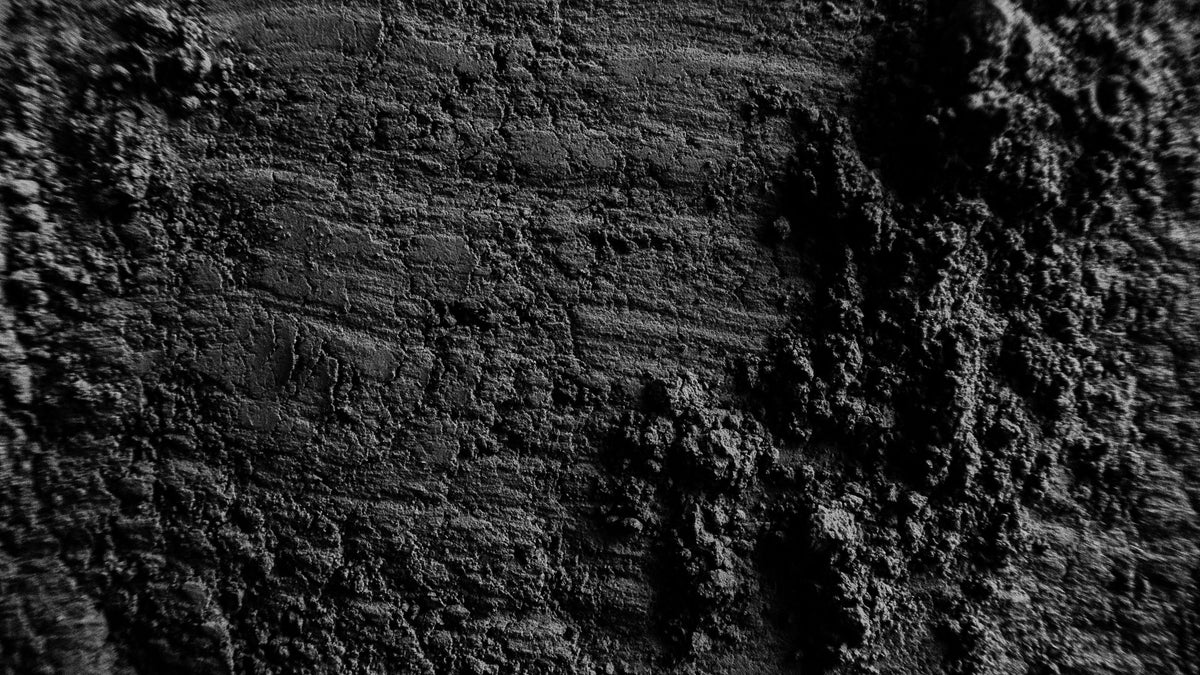 Macro black-and-white split of a smooth combed clay surface beside a mounded rough one.