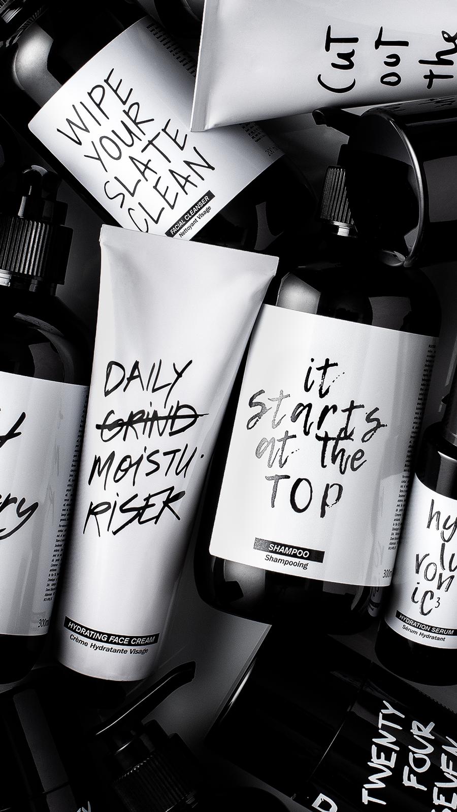 Black and white flatlay piling the facial cleanser, hydrating face cream, shampoo and hydration serum together.